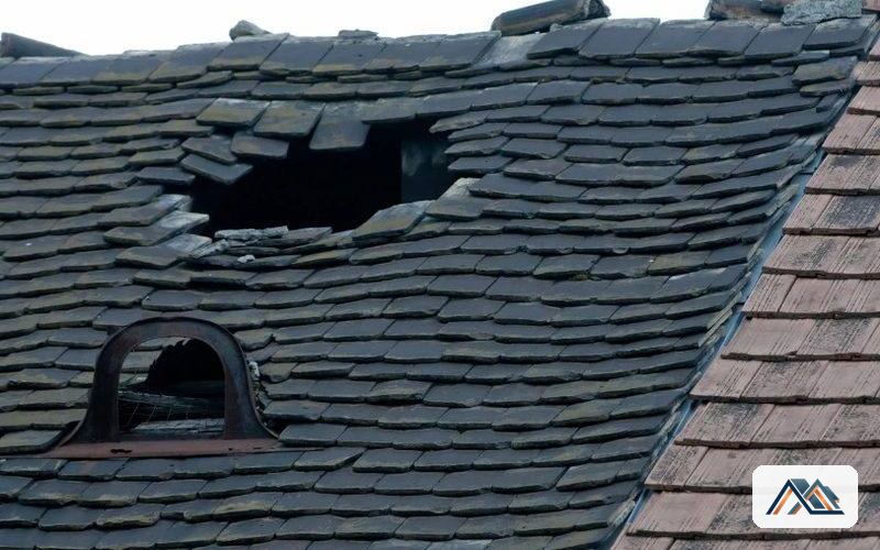 Daño en cubierta de pizarra tras un temporal Cubierta de pizarra con un hueco abierto junto a una buhardilla tras un temporal