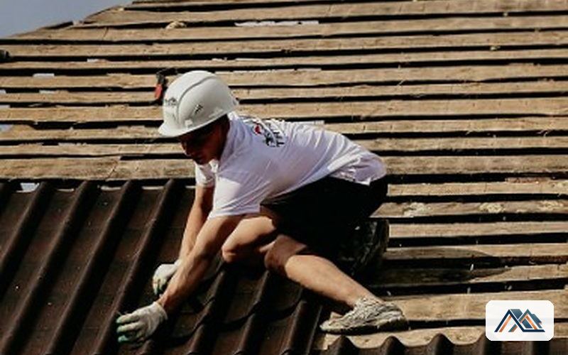 Trabajo sobre cubierta de placa ondulada Operario con casco trabajando sobre una cubierta de placa ondulada