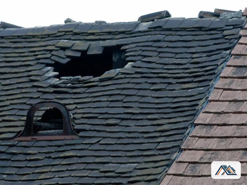 Cubierta de pizarra con piezas desprendidas en un edificio de Sarria