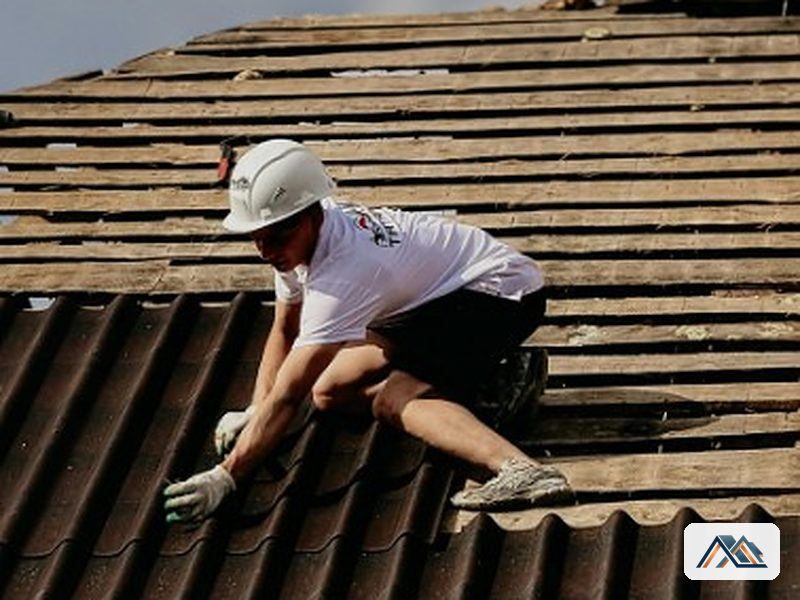 Tejador desmontando el canalón antiguo sobre la cubierta de la vivienda